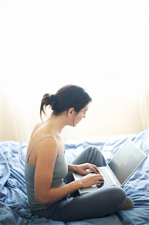 simsearch:700-00083403,k - Woman Sitting on Bed and Typing on Computer Stock Photo - Rights-Managed, Code: 700-00160064