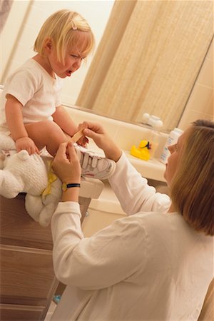 Mother Putting Bandage on Daughter's Leg Stock Photo - Rights-Managed, Code: 700-00263147