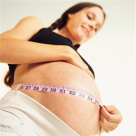 pregnant low angle - Pregnant Woman Measuring Belly Stock Photo - Rights-Managed, Code: 700-00367627