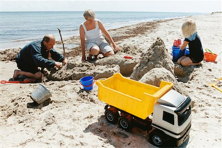 simsearch:400-04423521,k - Grands-parents et petite-fille bâtiment Sandcastle Photographie de stock - Rights-Managed, Code: 700-00477508