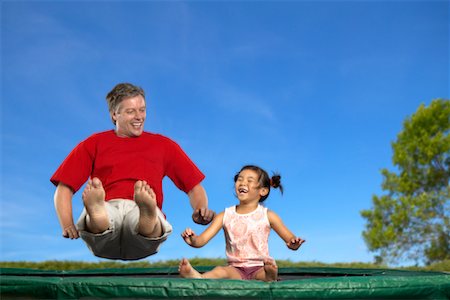 Man and Girl Bouncing on a Trampoline Foto de stock - Con derechos protegidos, Código: 700-00525034