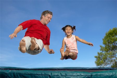 Man and Girl Bouncing on a Trampoline Foto de stock - Con derechos protegidos, Código: 700-00525033