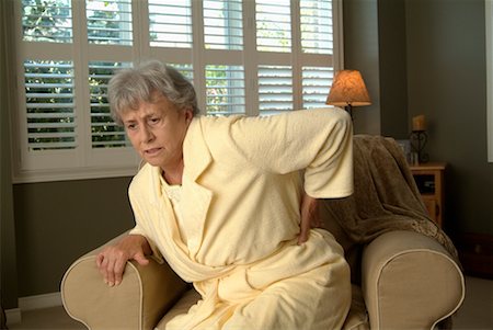 feeble - Woman with Back Pain in Chair Stock Photo - Rights-Managed, Code: 700-00520266