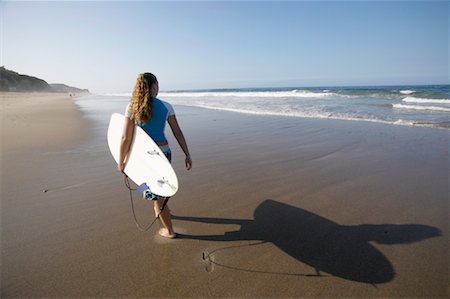 simsearch:700-00522399,k - Femme qui marche sur la plage avec planche de surf Photographie de stock - Rights-Managed, Code: 700-00546174