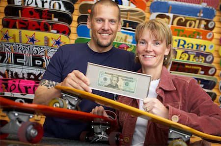 Couple Holding Framed Dollar Bill in Skateboard Store Stock Photo - Rights-Managed, Code: 700-00546728