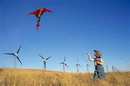 Child Flying Kite by Wind Turbines Stock Photo - Rights-Managed, Code: 700-00549347