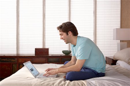 simsearch:700-00040657,k - Man Using Laptop in Bedroom Stock Photo - Rights-Managed, Code: 700-00557354