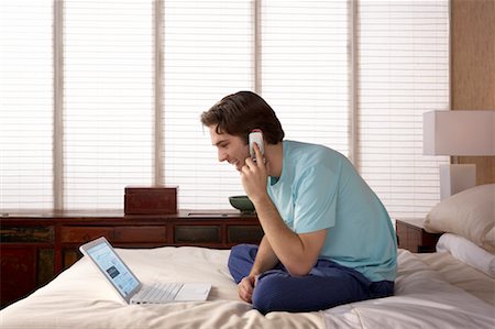 simsearch:700-00040657,k - Man Using Laptop and Cell Phone in Bedroom Stock Photo - Rights-Managed, Code: 700-00557355