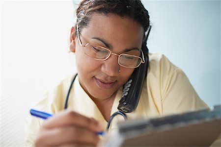 Doctor Writing on Clipboard, Talking on Telephone Stock Photo - Rights-Managed, Code: 700-00560472