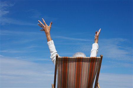 Woman in Beach Chair with Arms in Air Foto de stock - Con derechos protegidos, Código: 700-00606963
