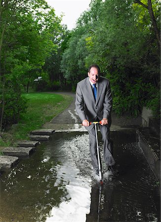 Businessman Riding Scooter Through Puddle Stock Photo - Rights-Managed, Code: 700-00611249