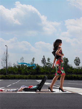 simsearch:600-00954685,k - Woman Walking in Parking Lot With Clothes Spilling Out Of Luggage Stock Photo - Rights-Managed, Code: 700-00644015