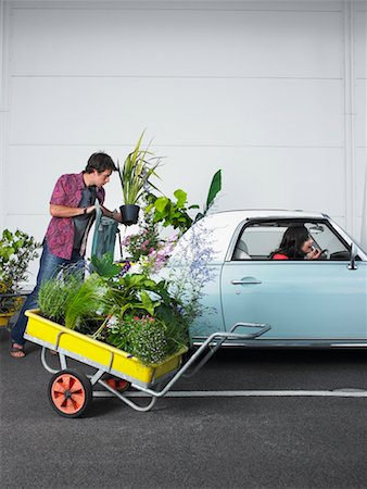 Man Loading Plants Into Trunk of Car, Woman Sitting in Passenger Seat, Applying Lipstick Stock Photo - Rights-Managed, Code: 700-00644041