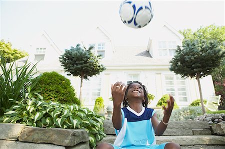 Boy Sitting On Steps Tossing A Ball in the Air Stock Photo - Rights-Managed, Code: 700-00681517