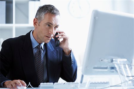 simsearch:700-03058969,k - Businessman Using Cellular Phone and Computer Stock Photo - Rights-Managed, Code: 700-00695807