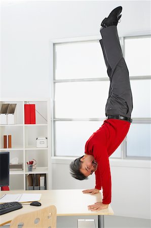 Businessman Doing Handstand on Desk Stock Photo - Rights-Managed, Code: 700-00711453