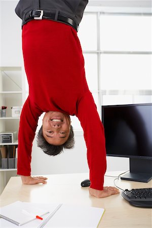 Businessman Doing Handstand on Desk Stock Photo - Rights-Managed, Code: 700-00711492
