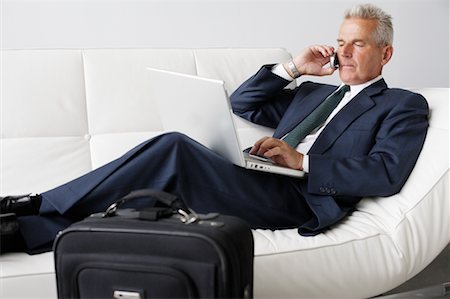 Businessman on Cellular Phone Using Laptop Stock Photo - Rights-Managed, Code: 700-00782237