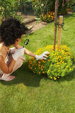 Woman Inspecting Flowers With Magnifying Glass Stock Photo - Rights-Managed, Code: 700-01073602