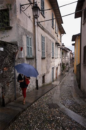 rainy and street scene - Woman Walking in the Rain, san Giulio Island, Italy Stock Photo - Rights-Managed, Code: 700-01083379