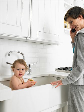 Mom Using Cellular Phone, Baby in Sink Stock Photo - Rights-Managed, Code: 700-01119876