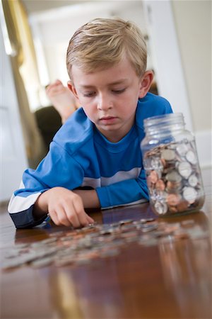 Boy Lying on Floor Counting Coins Stock Photo - Rights-Managed, Code: 700-01120592