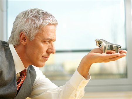 Businessman Holding Bull Ornament in Palm of Hand Stock Photo - Rights-Managed, Code: 700-01173288