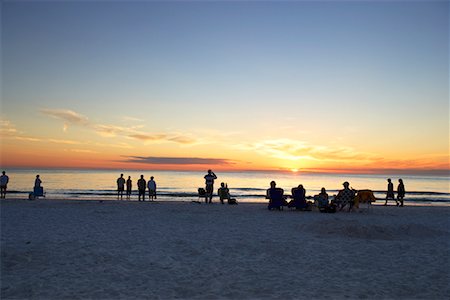 simsearch:600-03290198,k - Gens sur la plage en regardant le coucher du soleil Photographie de stock - Rights-Managed, Code: 700-01200228