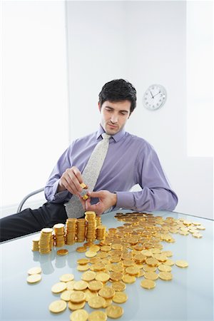 Homme d'affaires avec des pièces d'or Photographie de stock - Rights-Managed, Code: 700-01224039