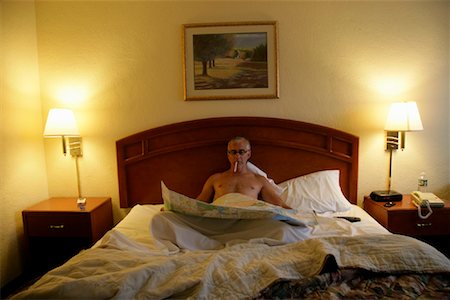 Man in Motel with Cigarette and Map Stock Photo - Rights-Managed, Code: 700-01236383