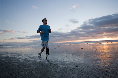 Man With Prosthetic Leg Running on the Beach Foto de stock - Con derechos protegidos, Código: 700-01260300