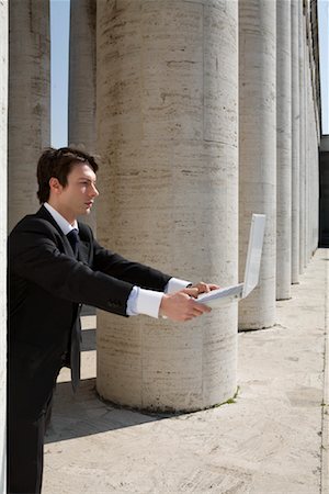 Homme d'affaires tenue d'ordinateur portable de piliers Photographie de stock - Rights-Managed, Code: 700-01378438