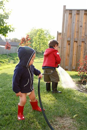 family backyard gardening not barbeque - Garçons d'arrosage de jardin Photographie de stock - Rights-Managed, Code: 700-01519661