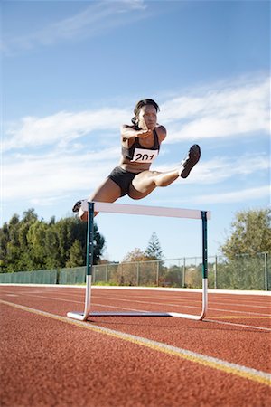 simsearch:700-00157314,k - Woman Jumping over Track Hurdle Stock Photo - Rights-Managed, Code: 700-01880224