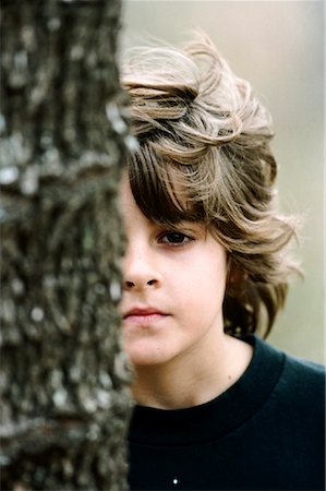 Boy Peeking from Behind Tree Foto de stock - Con derechos protegidos, Código: 700-02046874