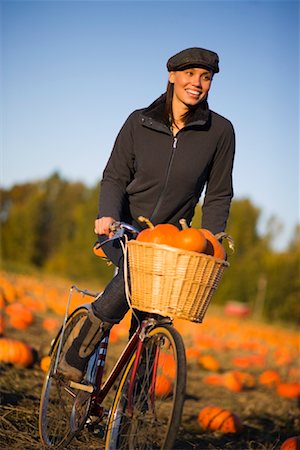 riding bike with basket - Woman Riding Bike in Pumpkin Patch Stock Photo - Rights-Managed, Code: 700-02176024