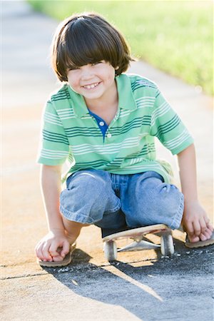 Portrait of Boy Sitting on Skateboard Stock Photo - Rights-Managed, Code: 700-02231929