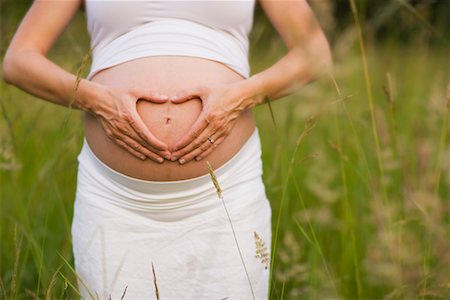 Pregnant Woman Making Heart Shape With Hands Over Belly, Portland, Oregon, USA Stock Photo - Rights-Managed, Code: 700-02263905