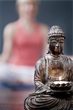 sitting buddha - Woman Practicing Yoga Meditation with Buddha in Foreground Stock Photo - Rights-Managed, Code: 700-02594291