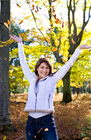 Portrait of Woman in Forest in Autumn, Throwing Leaves in the Air Stock Photo - Rights-Managed, Code: 700-02637847