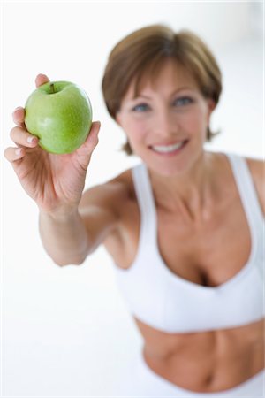 pretty 40 year old woman with brown hair - Woman in Athletic Wear with Apple Stock Photo - Rights-Managed, Code: 700-02637941