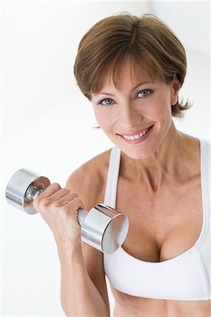 pretty 40 year old woman with brown hair - Woman Curling Free Weights Stock Photo - Rights-Managed, Code: 700-02637942