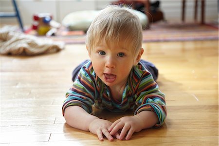 Baby Boy With Food on His Face Lying on Hardwood Floor Stock Photo - Rights-Managed, Code: 700-02791658