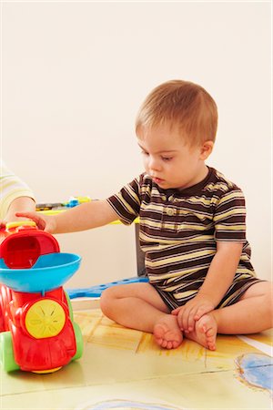 simsearch:700-00280017,k - Boy with Down Syndrom Sitting on Floor and Playing with Toy Stock Photo - Rights-Managed, Code: 700-02833636