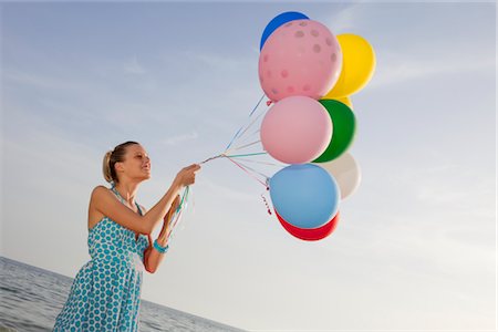 Woman on the Beach Holding a Bunch of Colourful Balloons Stock Photo - Rights-Managed, Code: 700-02943257