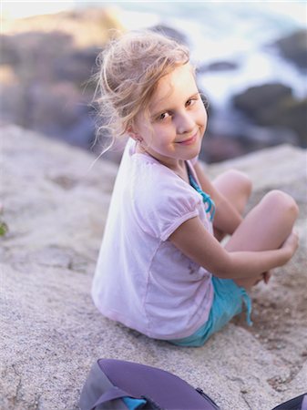 Young Girl Sitting on Rocks Near the Ocean Stock Photo - Rights-Managed, Code: 700-02954822