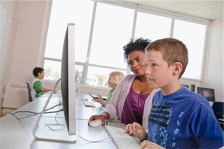 female teacher with young students - Teacher Helping Student on Computer Stock Photo - Rights-Managed, Code: 700-03017554