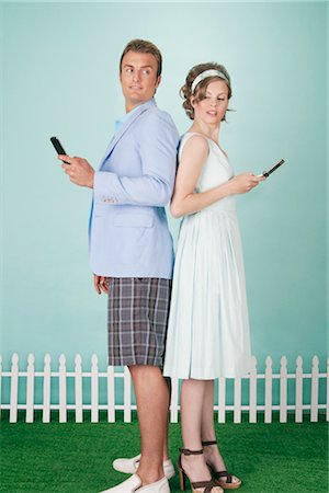 Couple Standing Back to Back Sending Text Messages Foto de stock - Con derechos protegidos, Código: 700-03059124