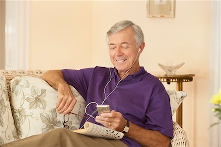 Man Sitting on Sofa Listening to Music Stock Photo - Rights-Managed, Code: 700-03075343