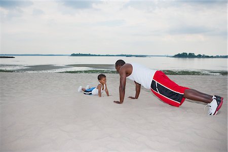 Father and Son Doing Push-ups on the Beach Foto de stock - Con derechos protegidos, Código: 700-03244348